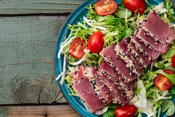 Salad with raw tuna , sesame and cherry tomatoes photography . Top view