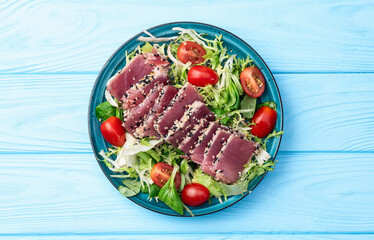 Salad with raw tuna , sesame and cherry tomatoes photography . Top view