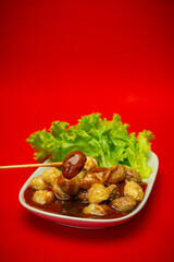 Spicy and sweet, meatball, lettuce and sauce in plate and isolated on red background
