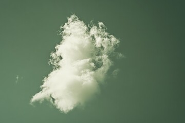 A tall, vertically stretched cloud captivates attention as it stands against a green-tinted sky, representing transcendence and elevation in visual harmony.
