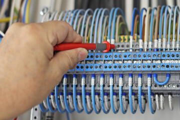 Measurement of electrical parameters in a switchboard using a multimeter.