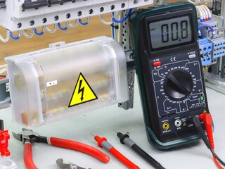 Measurement of electrical parameters in a switchboard using a multimeter.