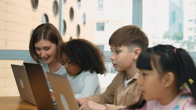 Smart teacher teaching and looking student using laptop at classroom. Professional instructor explained about programing engineering code or prompt while studying and learning program. Erudition.