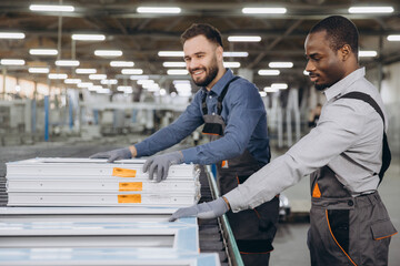 Factory workers producing PVC windows and doors checking quality on production line