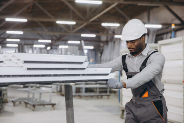 Factory worker moving aluminum window profiles