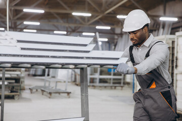 Fototapeta premium Factory worker moving aluminum profiles for windows and doors production