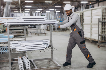 Factory worker moving aluminum or pvc window and door frame profiles