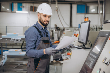 Factory worker operating industrial machinery for aluminum and PVC windows and doors production