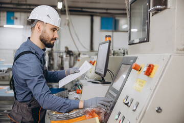 Factory worker operating machinery for aluminum and pvc windows and doors production