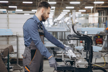 Factory worker operating industrial machinery producing aluminum and pvc windows and doors
