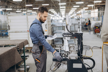 Factory worker operating machinery for aluminum and PVC windows and doors production