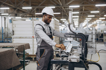 Factory worker operating machinery producing aluminum and PVC windows and doors