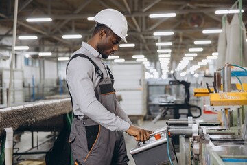 Factory worker operating machinery producing aluminum and pvc windows and doors