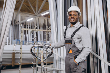 Factory worker handling aluminum and pvc windows and doors profiles