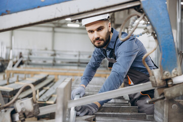 Factory worker cutting aluminum profiles for windows and doors production