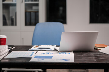 A quiet night desk with a glowing computer screen displaying a graph, a steaming coffee cup beside it. The desk exudes productivity and focus, surrounded by calm and silence