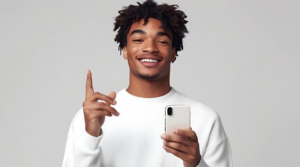 Young Man with Smartphone Smiling and Gesturing to Join Him Engaging Scene on Light Gray Background