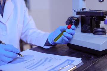 Close-up of a male scientist analyzing blood vessels in a modern laboratory. He is experimenting...