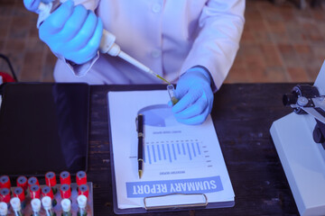 Close-up of a male scientist analyzing blood vessels in a modern laboratory. He is experimenting...