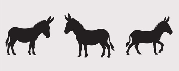 Three black silhouettes of donkeys in various poses on a plain gray background