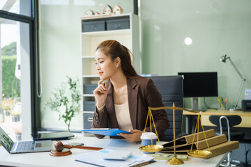 A young female lawyer sits at her desk in the office, providing online legal advice professionally....