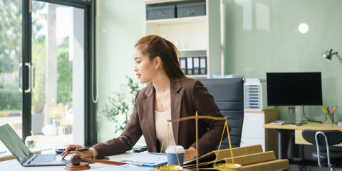 A young female lawyer sits at her desk in the office, providing online legal advice professionally....