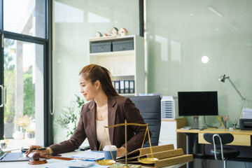 A young female lawyer sits at her desk in the office, providing online legal advice professionally....