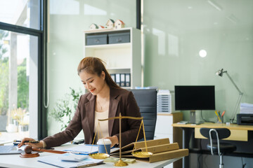 A young female lawyer sits at her desk in the office, providing online legal advice professionally....