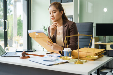 A young female lawyer sits at her desk in the office, providing online legal advice professionally....