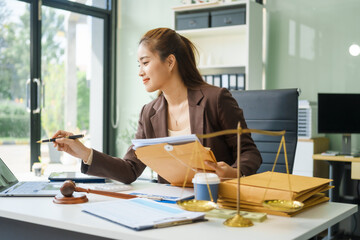 A young female lawyer sits at her desk in the office, providing online legal advice professionally....