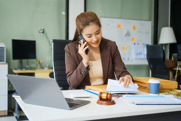 A young female lawyer sits at her desk in the office, providing online legal advice professionally....