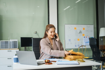 A young female lawyer sits at her desk in the office, providing online legal advice professionally....