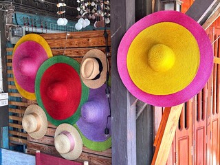 A vibrant collection of colorful hats is beautifully hanging on a wall
