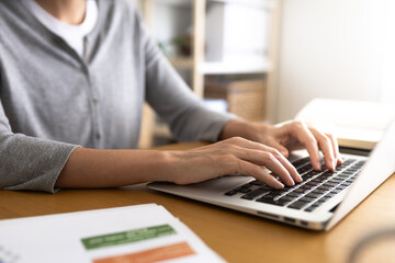 Close up of hands typing laptop. Selective focus on hands. Blurred background.