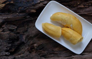 Durian in a white plate on a wooden background