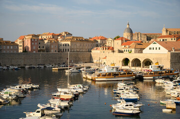 The beauty of Dubrovnik captured in the morning, from the seaside pier. The calm waters reflect the city’s historic charm, making it an ideal image for tourism, coastal, and architectural themes.