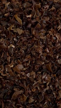 Dried, hydrated and chopped mun mushrooms as background texture. Table spin. Vertical video.