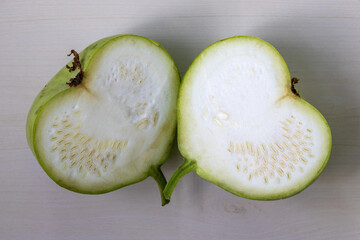 Fresh green round gourd calabash, sliced in half. Top view.