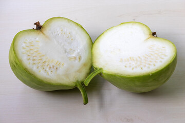 A fresh green round gourd calabash, cut into two equal halves.