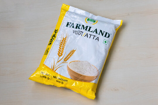 A packet of Farmland Atta, a renowned brand of wheat flour in Bangladesh, rests on a wooden surface. Farmland Atta is highly regarded for its superior quality and consistent, delicious flavor.