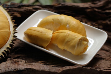 Durian in a white plate on a wooden background