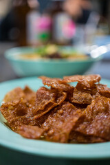 Sliced sheets of dried and crispy pork on dish. Sweet pork sheet