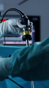 Vertical Screen: Close-up of surgeons performing minimally invasive procedure with advanced medical equipment in a sterile operating room. Concept of laparoscopic surgery, teamwork, modern healthcare