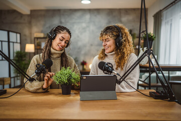 Two young women stream audio podcast about home plant at home studio
