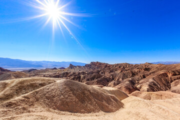 A desert landscape with a bright sun shining on it