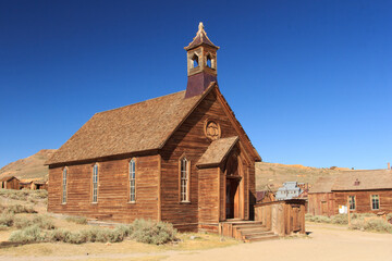 A small church with a steeple sits in a desert