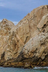 A rocky cliff with a blue sky in the background