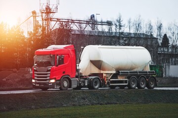 Red truck pulling a large tanker trailer