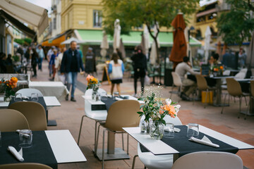 Outdoor Tables with Glassware in a Vibrant Alley on the French Riviera