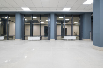 panorama view in empty modern hall with columns, doors and panoramic windows at night